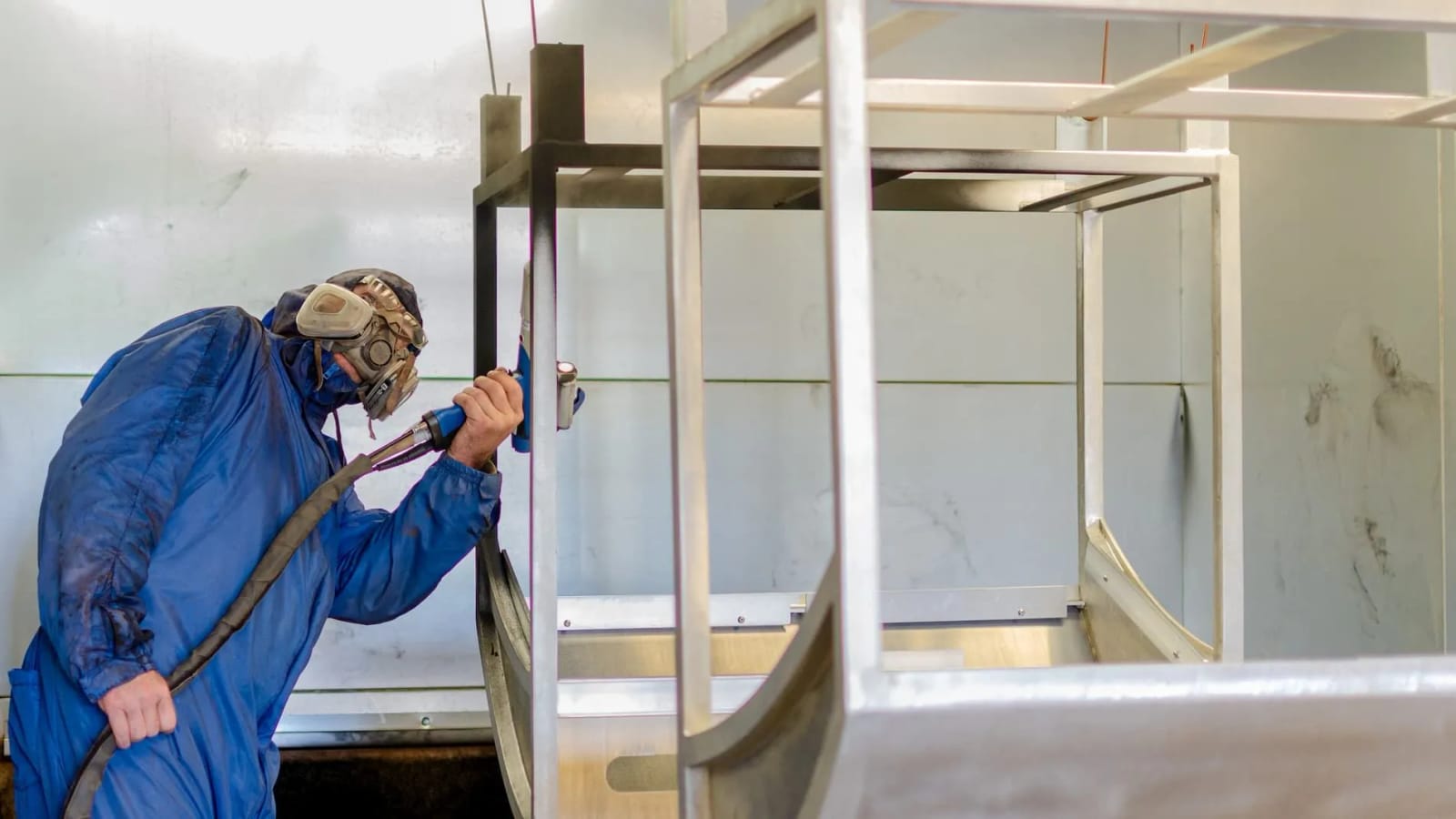 Applying powder coat to bare metal frames in the spray booth